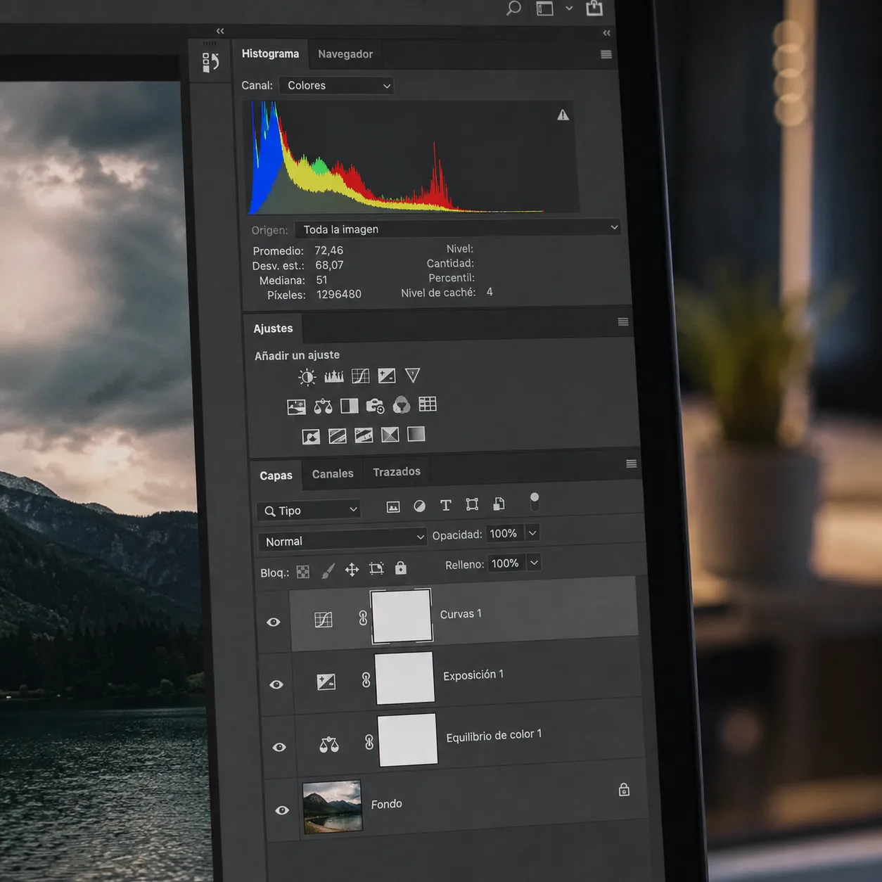Una toma fotorrealista de cerca de una pantalla de monitor mostrando la interfaz de Adobe Photoshop, específicamente el panel de capas de ajuste y un histograma, en un ambiente de oficina moderno con luz tenue.